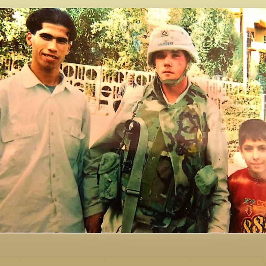 MAKING FRIENDS Michael Saunders, center, poses for a photo with Iraqi civilians in 2003-2