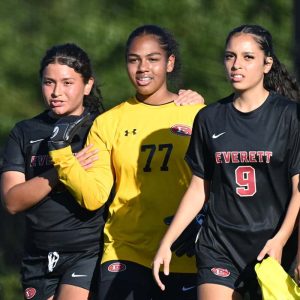 Leilany Rodriguez shows some support to teammates, goalie Ashley Heath, Gabriella Lones Rivera and Sofia Arana-Quintanilla during last week’s action against Malden. (Advocate file photo)