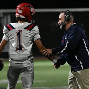 RHS Pats’ Head Coach Louis Cicatelli congratulates senior Geo Woodward on the final touchdown of the game, solidifying Cicatelli 100th career win during last week game against Malden.  (Advocate file photo)