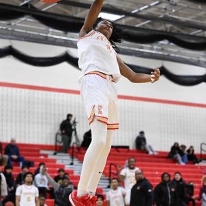Tide’s Jaysaun Coggins hangs on the rim after a dunk for the Tide in recent action against Lynn English.  (Advocate file photo)