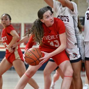 6.	Julianna Rivera pushes her way to the basket as a Revere guard stands over her.