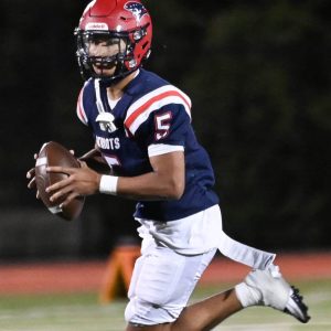 Patriot quarterback Danny Hou looks for an open receiver.