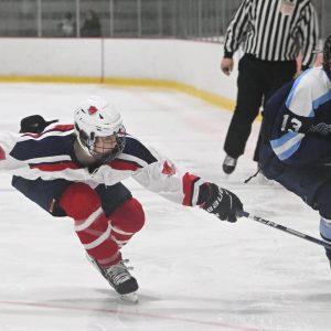 Freshman Tommy Cronin reaches for the puck in recent action against Medford.