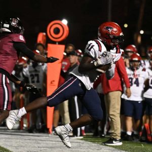 Charles Dobre worked to stay inbounds after making a reception during recent action against Lynn English. (Advocate file photos)