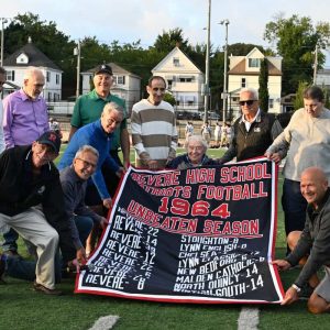 A banner for the 1964 Revere High School football team will be hung in the Revere High School field house. On hand from the 1964 Revere High School football team displaying the banner were, Victor Mancini, Paul Nuell, Phil Alexander, John DelGaizo, Jack Stasio, Bob Medeiros, Bob Carrabes, Frank Adreottola and Frank Bloom. A documentary film about the team and produced by RHS coach Brandon Britto is in production and set to release November 23, 2024, a week before the Thanksgiving Day game.