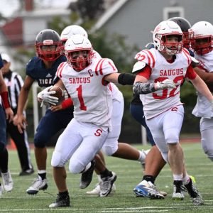 OFF AND RUNNING: Sachems Capt. Tommy DeSimone carried the ball during last week’s action against Lynn Tech. (Advocate photo by Emily Harney)