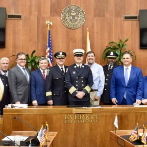 Fire Chief Joseph Hickey alongside his father, Joseph Hickey, Mayor Carlo DeMaria, Police Chief Paul Strong, Sen. Sal DiDomenico, Bishop Robert Brown and members of the City Council. (Photo courtesy of the City of Everett)