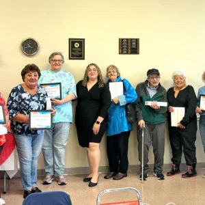 Students posed with the free iPads and Certificates they received upon graduating from a tech training with Mystic Valley Elder Services (MVES). Pictured with them are MVES Technology Access Program Coordinator Carla Matute (center) and Amy Seidenfuss (far left), who volunteers with the MVES program.