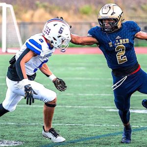 Malden High sophomore star running back Jayden McGuffie ran for 255 yards and scored all the Tornado points, 2 TDs and the winning margin, a 2-pt. conversion in a 14-12 Malden win in the home opener. Above, McGuffie stiff arms Somerville’s Ryan Louis on his way to a 66-yard TD run in the first quarter. (Advocate Photo/Henry Huang)