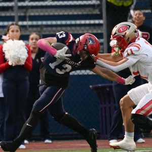 Reda Atoui pushes off an Everett defender as he gains some yardage for Revere.