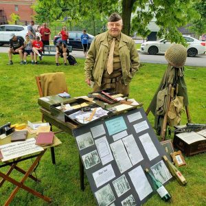 HISTORY ON THE LAWN: Saugonian Stephen H. Belyea set up his World War II display at Veterans Memorial Park last Saturday for people who came to watch Saugus’s Annual Memorial Day Parade. (Saugus Advocate photo by Mark E. Vogler)