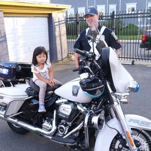 Malden Patrolman Patrick Manolian with Ella Tan trying his bike on for size.
