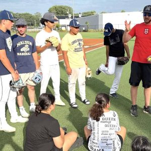 Malden High coach Mike Nicholson is shown talking to the campers last week. Some of his assistants, from left: Devin Otero Milonopoulos, Kyle Nickerson, Nicholas D’Anna, Davante Layne, Jaylen Fuentes Rivera and Leandro Ortiz Castro. (Courtesy/Malden Public Schools/Athletics)