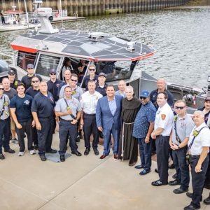 Father Mike Della Penna and Bishop Robert Brown (both shown at center) gave their blessings to the boat and crew of Marine 1.