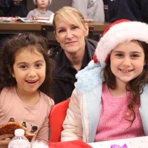 A.C. Whelan first grader Denise Bonilla, at left, Hill elementary second grader Emily Waldron, and Police Captain Amy O’Hara.