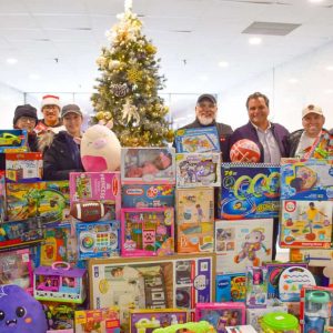 State Senator Sal DiDomenico and Mayor Carlo DeMaria are joined by supporters behind a large pile of toys that were donated by the DiDomenico Foundation to the City of Everett’s Toy Drive.  (Courtesy of the City of Everett)