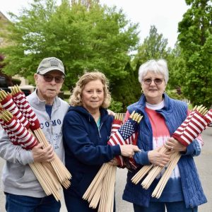 Local residents joined together last year to place U.S. flags on the graves of veterans at Woodlawn Cemetery. (Advocate file photo)