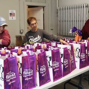 June Dennen, Kathy Savage and Hajar Bichou carefully fill the bags with fresh fruits and vegetables.