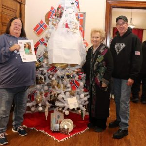 Shown from left to right: daughter-in-law Kristen Waldowski, M.E.G. Foundation President Janice Jarosz and son-in-law Stephen Waldowski by the M.E.G. Foundation tree in memory of M.E.G. Foundation board member “Lee” Dyment, 96, who died this year.