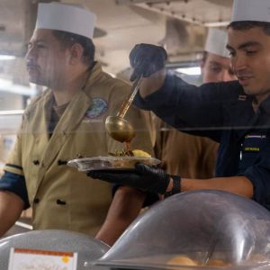 Lt. David Palencia, from Malden, Massachusetts, serves food during a Thanksgiving meal on the mess decks onboard Nimitz-class aircraft carrier USS Ronald Reagan (CVN 76), while in-port Naval Base Kitsap in Bremerton, Washington, Nov. 28, 2024. Ronald Reagan provides a combat-ready force that protects and defends the United States, and supports alliances, partnerships and collective maritime interests in the Indo-Pacific region. (U.S. Navy photo by Mass Communication Specialist 2nd Class Caleb Dyal)