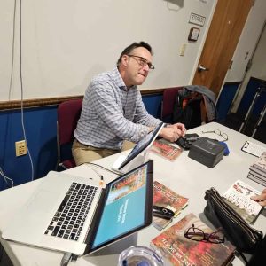 A BOOK SIGNING AFTER THE TALK: Ted Reinstein sold autographed copies of his new book, “Travels Through the Heart and Soul of New England: Stories of Struggle, Resilience, and Triumph.” (Saugus Advocate photo by Mark E. Vogler)