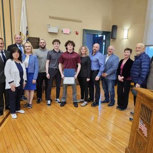 A COMMENDATION FROM SELECTMEN: Sam LoRusso (at center), a Saugus High School student athlete who has excelled in the sport of wrestling, flanked by family and members of the Saugus Board of Selectmen, held a commendation he received from selectmen last week for finishing eighth in New England competition – the best that any Sachem athlete has ever done in the sport. LoRusso went 45-0 combined during the last two regular seasons. He finished with a 5-2 record in the New England tournament. LoRusso was invited by selectmen to be a guest at their April 16 meeting. (Saugus Advocate photo by Mark E. Vogler)