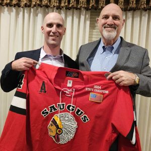 A HALL OF FAME LEGACY: Hall of Fame inductee Robert Gannon and his dad, Steve – a Hall of Famer who was inducted in 1988 – hold the jersey that Robert wore as a member of the 2004 Saugus High State Hockey champions. (Saugus Advocate photo by Mark E. Vogler)