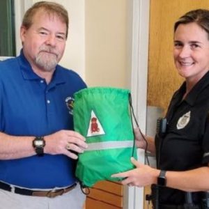 A MASONIC OUTREACH PROGRAM: Right Worshipful Alan Welch of William Sutton Lodge presents Officer Alison Cooper of the Saugus Police Department a Project Delta bag. (Courtesy photo to The Saugus Advocate)