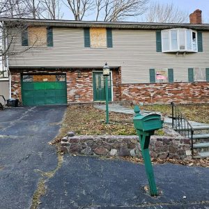 A NEIGHBORHOOD CONCERN: 22 residents who live in the area near 31 Susan Drive signed a petition with Building Commissioner Michael LaVecchia of the Inspectional Services Department and Saugus Police Chief Michael Ricciardelli requesting that they enforce town bylaws to remove graffiti and address potential safety and health concerns at the vacant and deteriorated property. (Saugus Advocate photo by Mark E. Vogler)