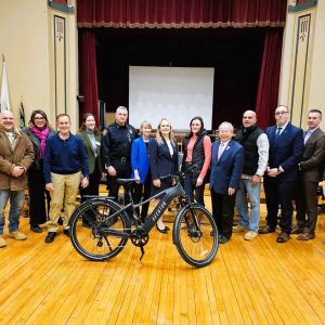 A UNITED FRONT: A group of town officials and participants in the E-Bike Forum held in the second-floor auditorium at Saugus Town Hall took a curtain call at the end of the Feb. 5 event. It was a night when top town officials and the members of the state legislative delegation gathered for serious discussion of how the town should approach an important public safety issue. (Saugus Advocate photo by Mark E. Vogler)