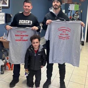 Derek Pothier, owner of DeBen’s Barbershop (pictured at left) and Tim Dresser (missing from picture), owner of 3rd Shift Apparel, graciously donated t-shirts for the First Annual EHS Football Clinic for grades 4 through 8. The clinic was hosted by EHS Head Coach Justin Flores and his staff. Also in the picture is Mance McKinney, a big fan of Everett Football and Coach Flores. We would like to thank local businesses for their generous support. (Courtesy photo)