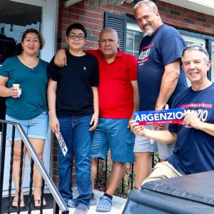 Paul Argenzio is shown with one of the many families he met during his evening of campaigning in Ward 4 recently. Shown with the candidate holding the bumper sticker is campaign worker Michael Norton.