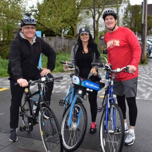 Mayor Robert J. Van Campen, Councilor Stephanie Martins, and Executive Assistant to the Mayor Chris Connolly prepare to ride from the Northern Strand Community Trail at West & Wellington Plaza during Bike to Work Day 2026.
