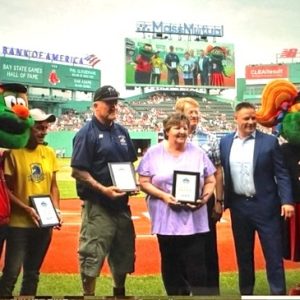 BAY STATE GAMES HALL of FAME: Shown above, from left: Red Sox Mascot Wally the Green Monster, Boston Marathon Race Director Dave McGillivray, Malden High Baseball and 36-year Bay State Games Coach Steve Freker, Trap Shooting Commissioner Debra Terho, Bay State Games Board Chair Phil Gloudemans, Board Vice Chair Dan Adams and Red Sox Mascot Tessie during the pregame ceremony at Fenway Park on June 29. (Courtesy/Bay State Games)