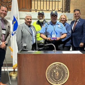 Malden’s Gina Hayes (shown above, center), who is stationed every morning and afternoon at the Ferryway School in Malden, was selected and honored as the Mass. Dept. of Transportation’s Safe Routes to School Program “Crossing Guard of the Year.” Along with officials from MassDOT and SRTS, attending the ceremony were state Rep. Paul Donato (D-Malden, Medford, fourth from left), Malden Mayor Gary Christenson and Ward 7 Councillor Chris Simonelli. (Courtesy/Mass. Dept. of Transportation)