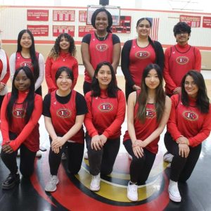 Everett High School Crimson Tide Varsity Crew — Shown, front row, from left to right, are: Marielle Ssegujja, Trinity Chen, Adrielly Dutra, Lexi Chen, and Lorrayne Freitas DaSilva. Shown, back row, from left to right, are: Head Coach Kate Mayes, Leyna Nguyen, Isabella Da Silva Vieira, Michelle Germain, Captain Gurkian Kaur, and Gabe Cunha.