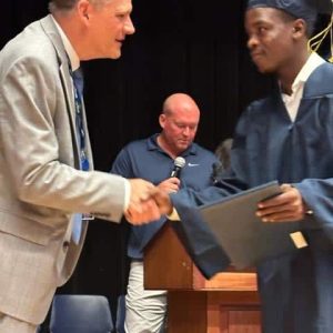 Superintendent of Schools Dr. Timothy Sippel and graduate Kevenson Tidor.