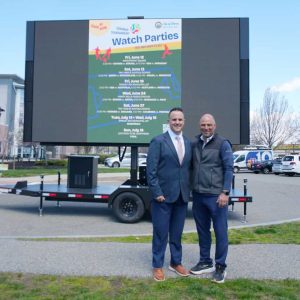 Mayor Patrick Keefe, left, and Revere Dept. of Recreation Director Michael Hinjosa are shown in front of the giant screen which will show the watch parties for the World Cup.
