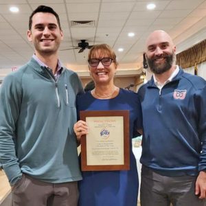Northeast Metro Tech Principal and Deputy Director Carla Scuzzarella holds her Educator of the Year Award as she is flanked by her sons Rob and Mike Scuzzarella. (Courtesy Northeast Metro Tech