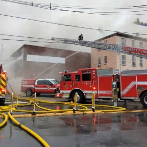 Firefighters from several communities battled a blaze beginning around 10 AM last Thursday at the former Russo Tux and Formal Wear located at the corner of Revere Beach Parkway at Rte. 16 and Garfield Ave. The building was mostly vacant, but a small church still used part of the building for weekend services. It was believed that chemicals for dry cleaning of the formal wear may have hindered the extinguishing of the fire for hours as police closed down the busy parkway while the smoke continued to fill the area. No injuries were reported. Shown are firefighters from Revere and Everett battling the blaze.  (Advocate photo by Mike Laye)