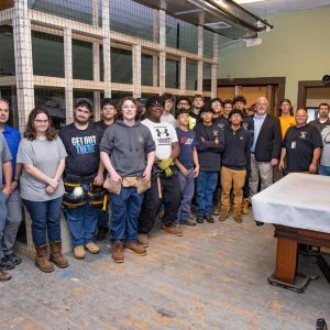 Northeast Metro Tech students who are working to renovate part of the Melrose Fire Headquarters stand with Ward Hamilton, Melrose’s representative on the Northeast Metro Tech School Committee at the fire station. (Courtesy Northeast Metro Tech)