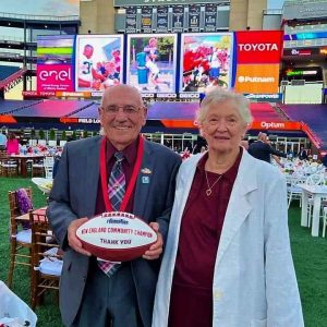 HAVING A BALL: Eugene Decareau is shown with his wife Arlene at Gillette Stadium in Foxborough last week where he was recognized by the New England Patriots Foundation with close to three dozen volunteers for their community service. (Courtesy photo to The Saugus Advocate by WIN Waste Innovations).