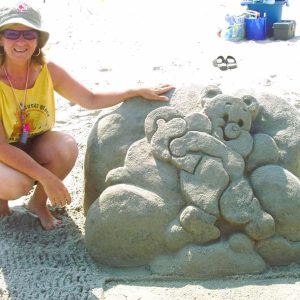 HER FIRST SAND SCULPTURE: Saugus resident Deborah Barrett-Cutulle stands alongside the care bear she created in 2005 during her debut at the Annual International Sand Sculpting Festival at Revere Beach. (Courtesy Photo to The Saugus Advocate)
