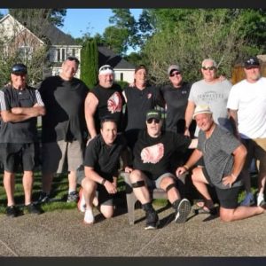 SAUGUS HOCKEY BUDDIES: From left to right: Standing: Jim Yantosca Sr., Charlie Ventre, Jim Yantosca, Kevin Andrews, Bob Maccini, Steven Ventre, Tom Langlois, Jeff Paoloni, Matt McGovern; kneeling: Paul Kinnally, Paul Ventre (Honorary Captain of the day) and Scott Brazis. This get-together was held at Jim Yantosca’s beautiful home in Southern New Hampshire in early June to celebrate the many years of Saugus High School hockey. A lot of memories and laughs were had by everyone. (Courtesy photo to The Saugus Advocate)