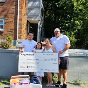 HOLDING THE CEREMONIAL GIANT CHECK: Former New England Patriots player Joe Andruzzi (right), a cancer survivor, joins Sheena LaMarra and her family in displaying the $3,000 grant for household expenses from the Lombardo Legacy Fund. (Saugus Advocate photo by Mark E. Vogler)
