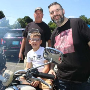 Revere residents Maximilian Averback, 6, with his father, Brian, and Newton Police Captain Ed Mead on a 2005 Harley-Davidson Road King.