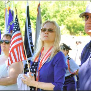 Holding the American flag with her wounded right hand, Board of Selectmen Chair Debra Panetta participated in the Memorial Day observance at Riverside Cemetery. (Courtesy photo to The Saugus Advocate by Charlie Zapolski)