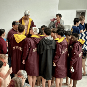 Coach giving the team a pep talk before the start of the meet.