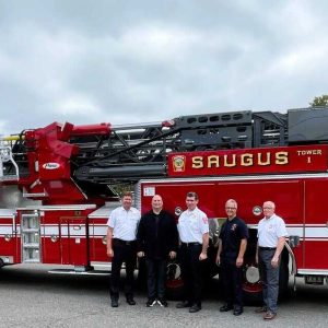 IT’S HERE! Town Manager Scott C. Crabtree and Saugus Fire Department officials welcomed the recent arrival of a new fire truck – Tower 1, which will replace Ladder 1 as a frontline vehicle operating out of the Public Safety Building on Hamilton Street. (Courtesy photo to The Saugus Advocate)