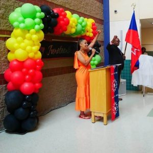 Lydia “The LovelySinger” Harrell sings “Lift Every Voice and Sing” – the Black National Anthem – as Malden Juneteenth Committee Member Eric Henry holds the Juneteenth Flag. (Courtesy Photo)